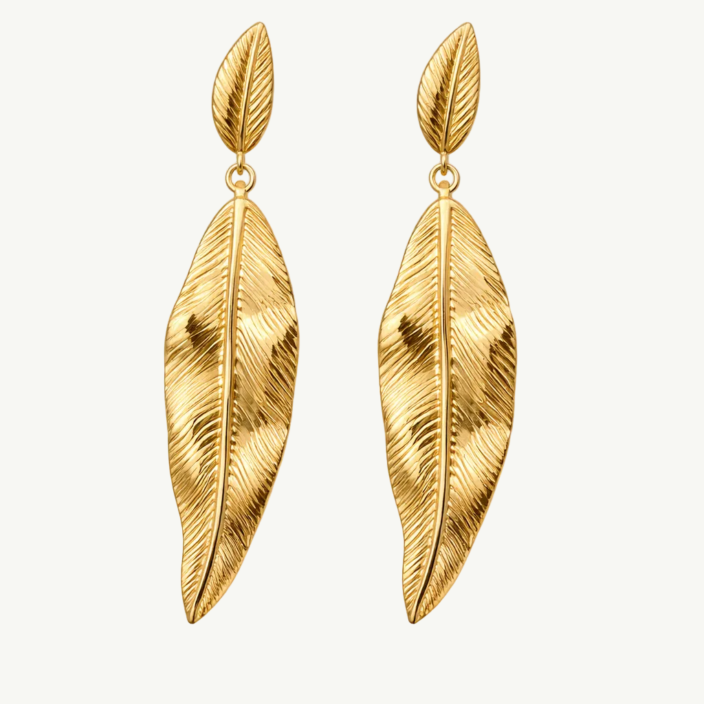 Gold leaf-shaped earrings on a white background