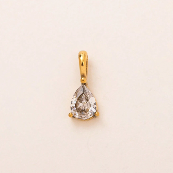 A pear-shaped clear gemstone pendant set in a gold bezel with a bail, centered on a plain off-white background.