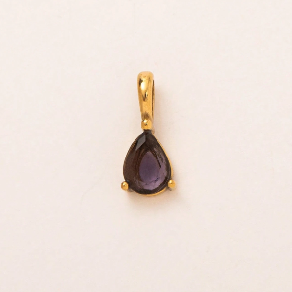 A gold teardrop pendant featuring a dark purple amethyst gemstone, set against a plain off-white background.