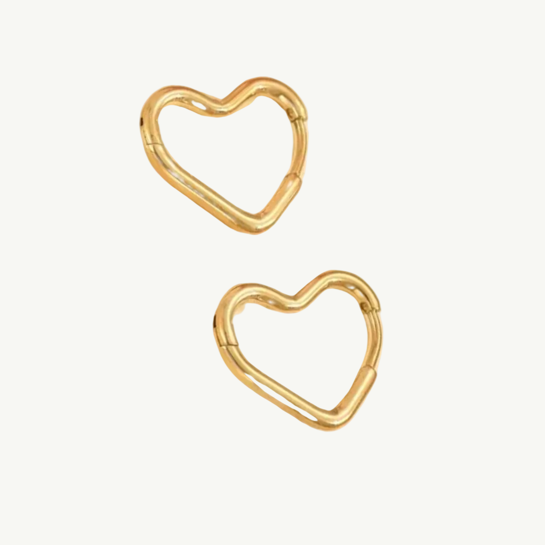 Two gold heart-shaped hoop earrings on a plain white background.