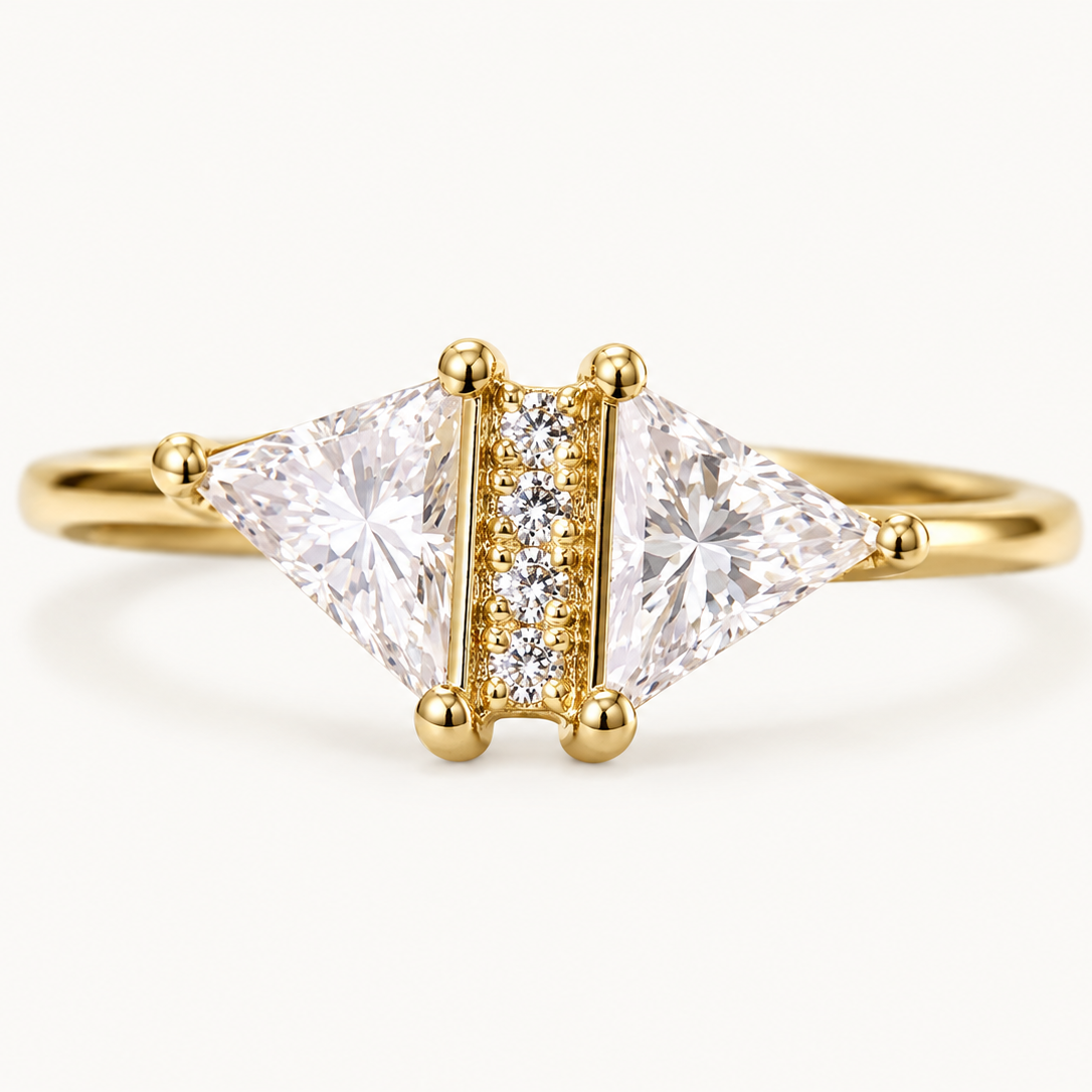 A yellow gold ring featuring a tri-oval diamond setting with two large princess-cut diamonds flanking a smaller center channel of round diamonds, shown on a clean white background.