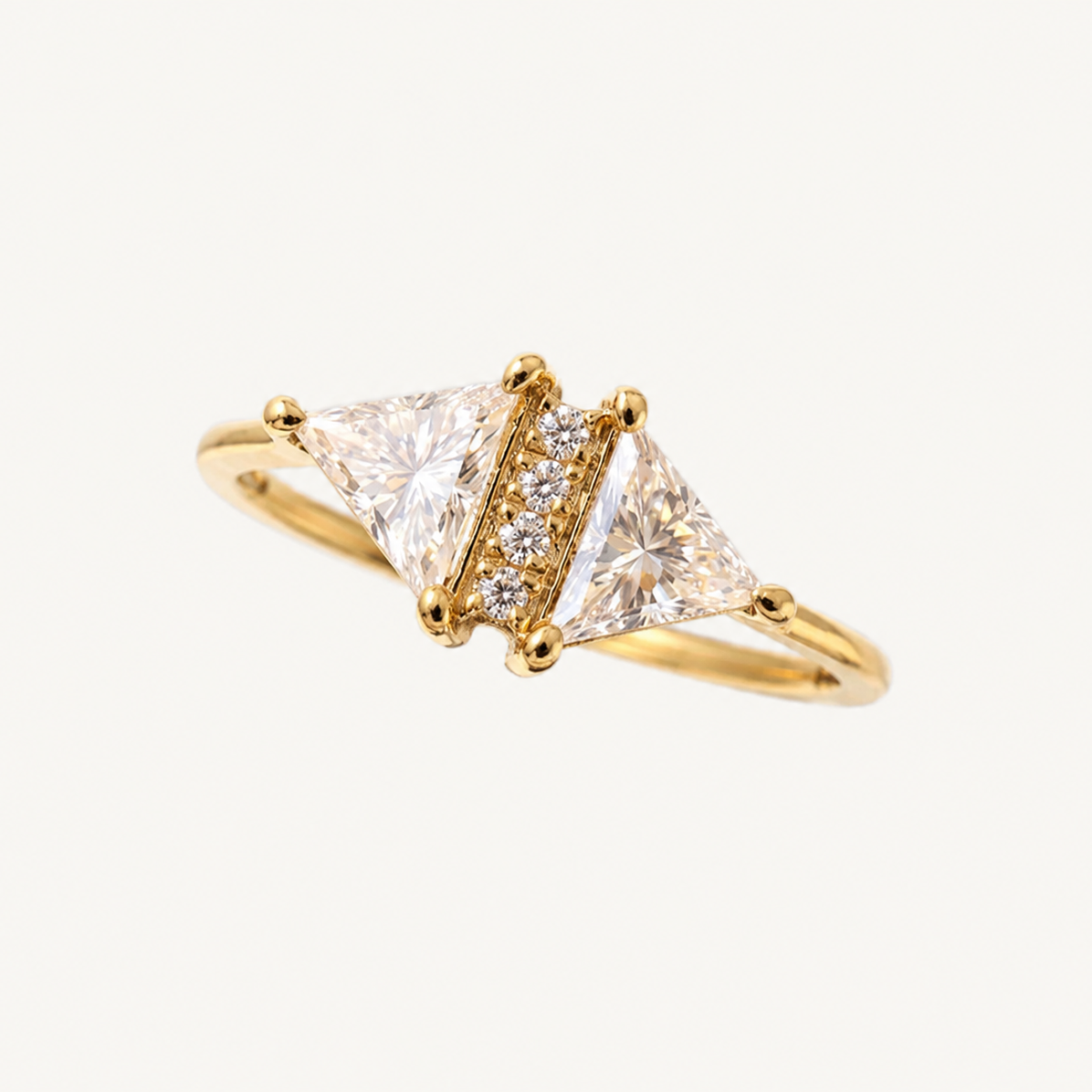 A yellow gold ring featuring two triangular clear gemstones flanked by a row of small round diamonds, set on a plain light background.