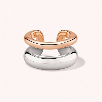 A two-tone minimalist ring with a polished rose gold upper band and a larger, smooth silver dome base, shown on a clean off-white background.