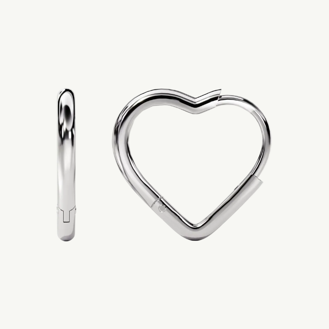 A pair of polished silver hoop earrings, one shown from a side profile view and the other from a front-facing three-quarter view, forming a heart shape when worn together. Photographed on a seamless white background.