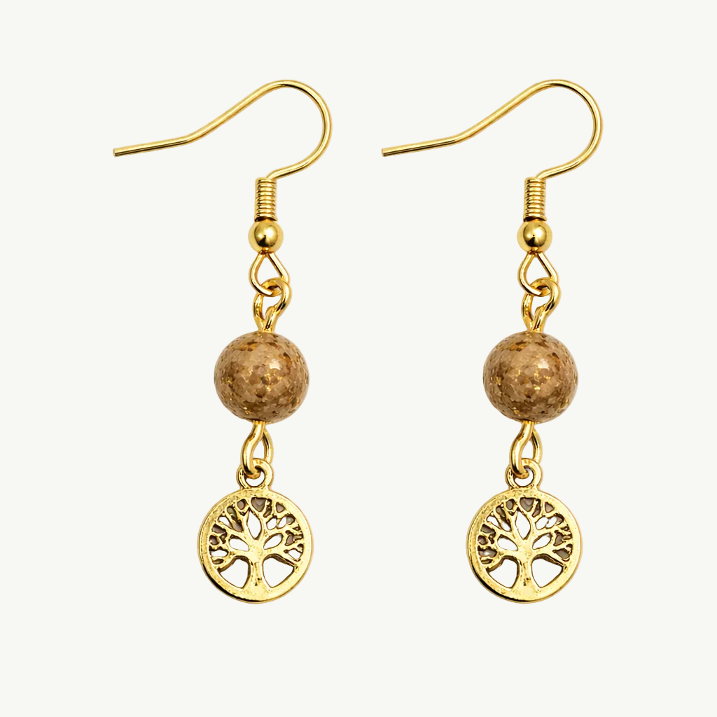 Gold earrings with tree of life charms on a white background