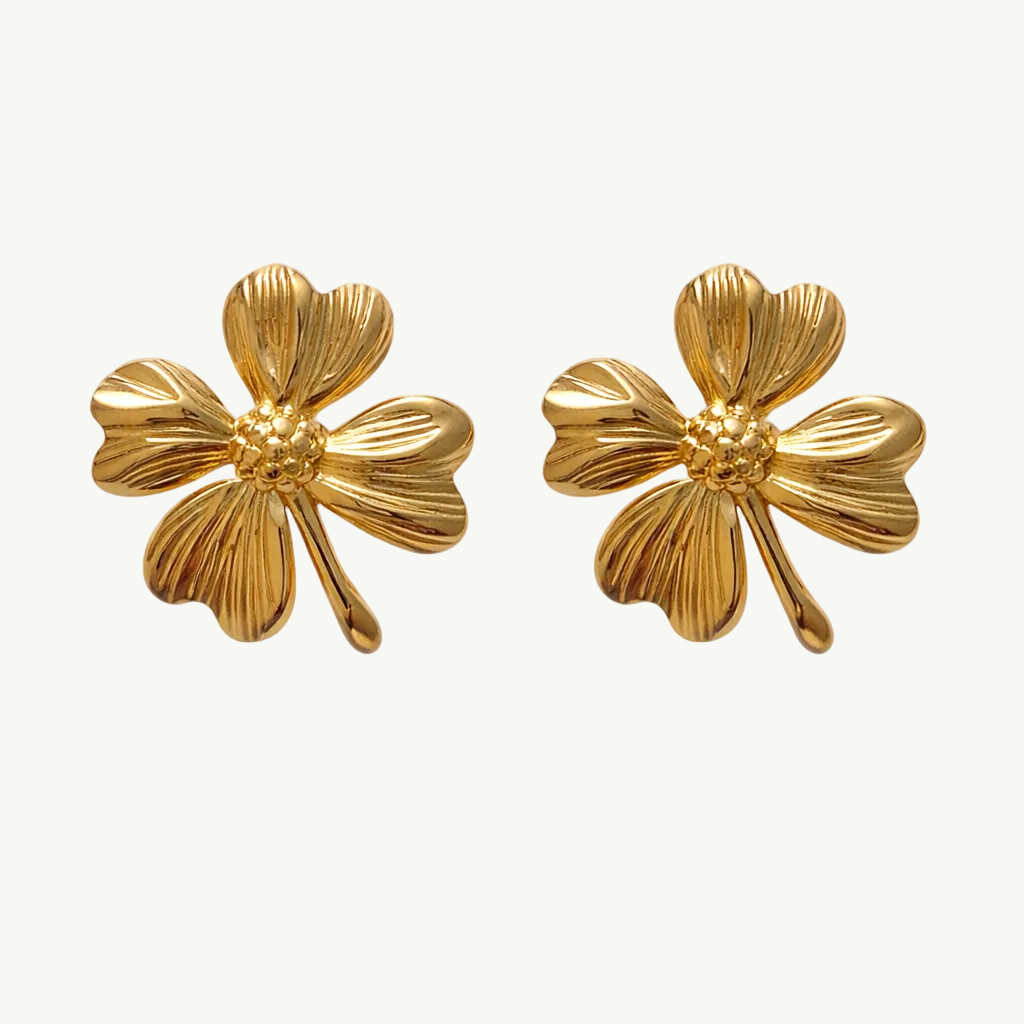 Pair of gold floral earrings on a white background