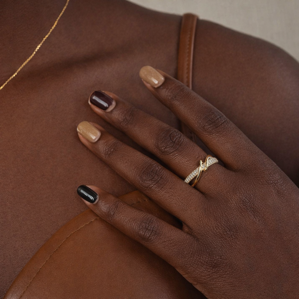 Hand with a gold ring on a brown leather surface